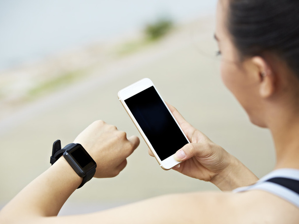 mujer con teléfono celular y rastreador de fitness
 - Foto, Imagen