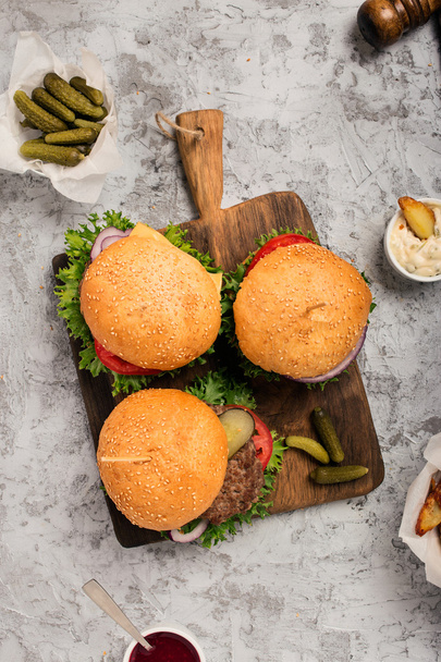 Three fresh homemade different hamburgers on wooden board - Photo, Image
