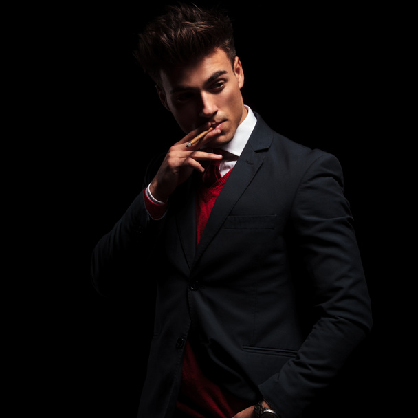 elegante jongeman in pak en stropdas roken - Foto, afbeelding