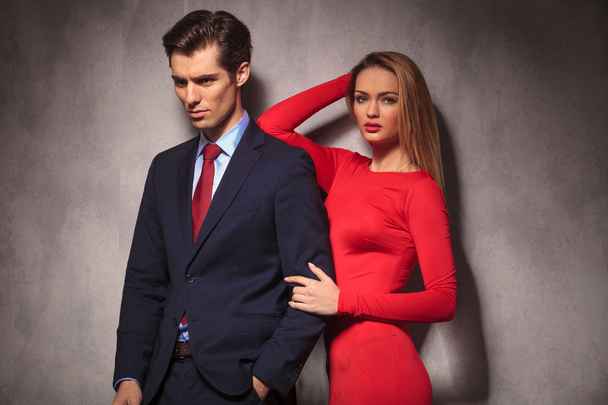 彼氏の肩に彼女の肘を傾いている赤いドレスを着た女性 - 写真・画像