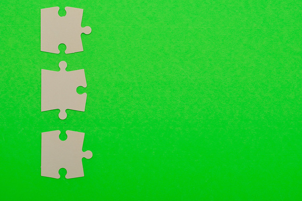 Білі шматочки головоломки ізольовані на зеленому фоні
 - Фото, зображення