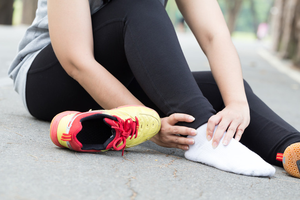 Urazy sportowe. Kobieta z bólem w kostce podczas joggingu - Zdjęcie, obraz