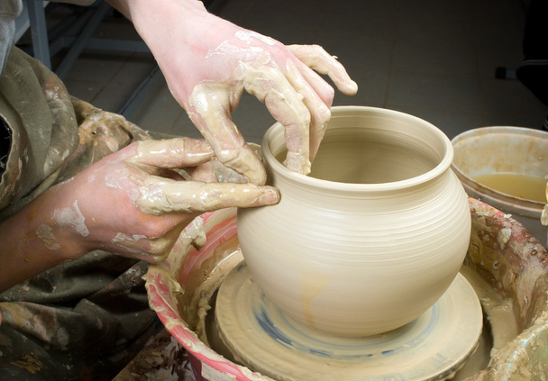 Руки гончаря, створюючи глиняну банку на колі
 - Фото, зображення