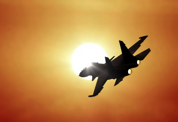 夕日の下で飛行するジェット戦闘機 - 写真・画像