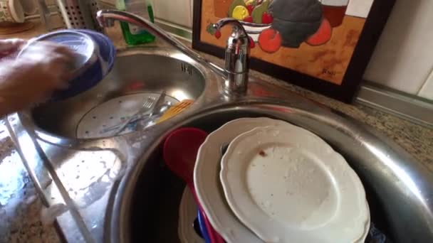 Femme d'âge moyen lave la vaisselle dans l'évier de la cuisine
 - Séquence, vidéo