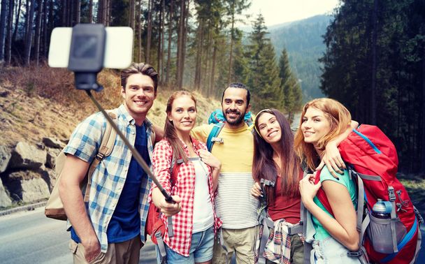 friends with backpack taking selfie by smartphone - Foto, afbeelding