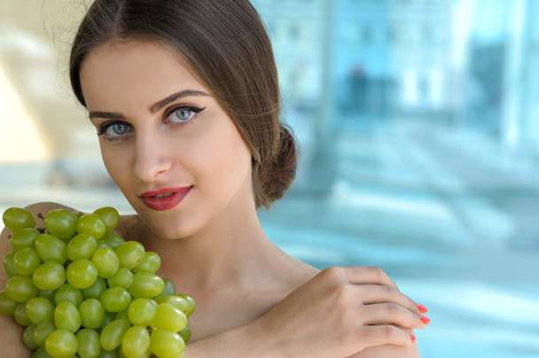 Woman holds grapes in the chest and hugs it - 写真・画像