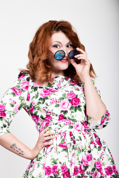 young stylish red-haired woman with curly hair and pretty face posing in sunglasses. expresses different emotions - 写真・画像
