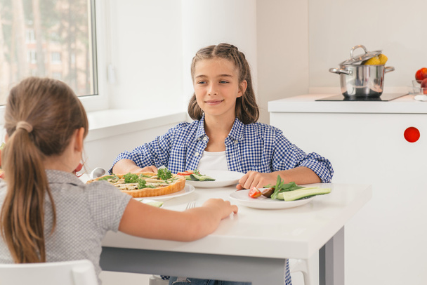 Söpöt pikkutytöt syövät terveellistä ruokaa keittiössä
 - Valokuva, kuva
