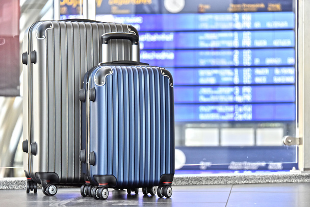 Дві пластикові проїзні валізи в залі аеропорту
 - Фото, зображення