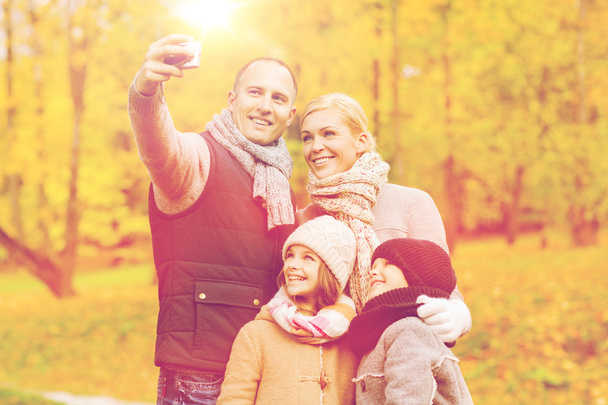 happy family with camera in autumn park - Zdjęcie, obraz