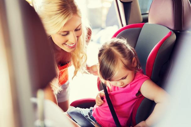 happy mother fastening child with car seat belt - Foto, immagini