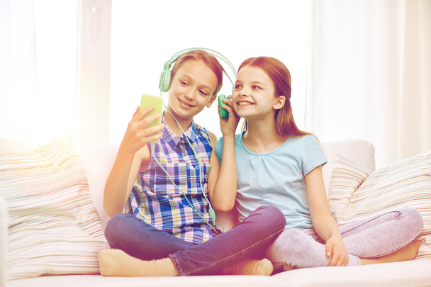 happy girls with smartphone and headphones - Zdjęcie, obraz