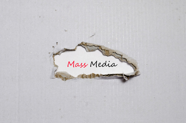 La palabra medios masivos que aparecen detrás del papel roto
 - Foto, imagen