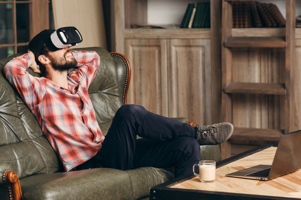 Young bearded man enjoying virtual reality glasses - 写真・画像