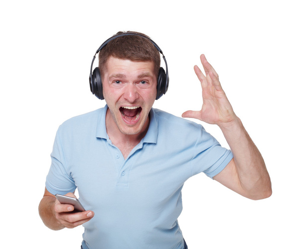 Szczęśliwy młody człowiek ze słuchawkami śpiewać i cieszyć się muzyką - Zdjęcie, obraz