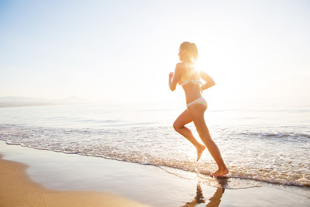 Caucasian woman jogging at seashore - Foto, Bild