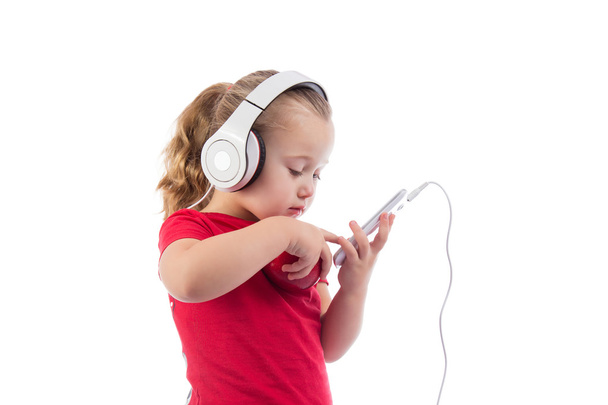 little girl with an apple and a phone  headphones - Zdjęcie, obraz