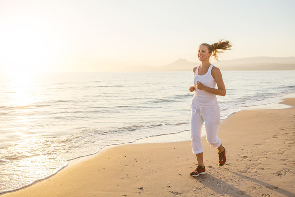 Caucasian woman jogging at seashore - Foto, afbeelding