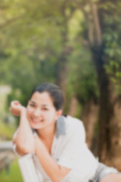 Efekt rozmycia młodej azjatyckiej kobiety relaksującej się na świeżym powietrzu patrząc szczęśliwy i uśmiechnięty - Zdjęcie, obraz