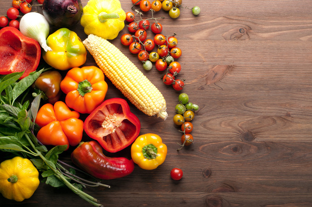 organic food concept. Fresh juicy vegetables such as cherry tomatoes, colorful peppers and corn on a brown wooden background. Vegetarian, vegan products. Space for text - Φωτογραφία, εικόνα