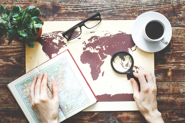 world map on a wooden table with girl hands - Photo, image
