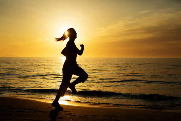 Caucasian woman jogging at seashore - Foto, imagen