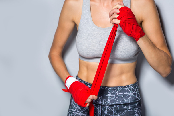 Woman is wrapping hands with red  boxing hand wraps - Zdjęcie, obraz