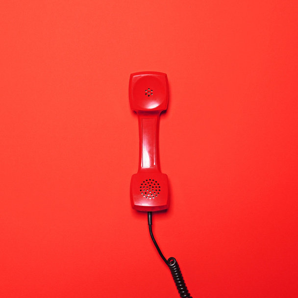 Retro červené telefonní trubice na červeném pozadí - ploché rozložení - Fotografie, Obrázek