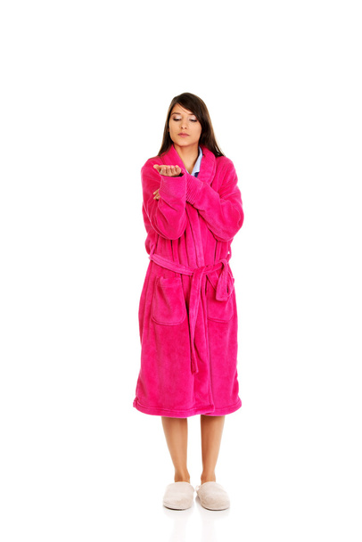Woman in pink bathrobe showing empty palm. - Zdjęcie, obraz