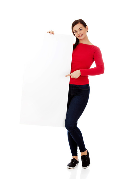 Beautiful student woman pointing on blank board - Zdjęcie, obraz
