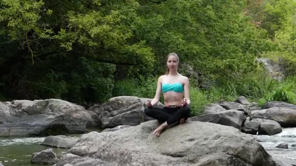若くて美しい女の子は、岩の上の瞑想です。深く息を山川の新鮮な空気. - 映像、動画