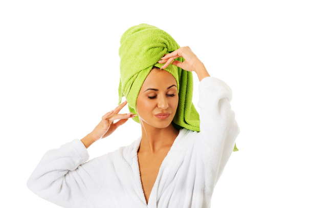 Woman in bathrobe touching her head - Foto, Bild