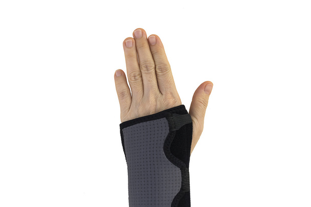 Рука в черном запястье повязка с изолированным
. - Фото, изображение