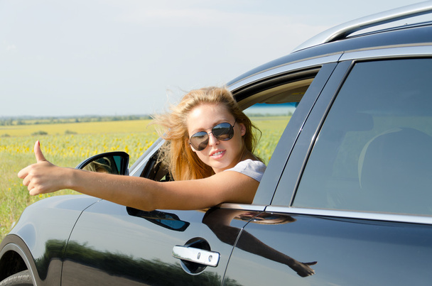 vrouw in auto geven van een duim omhoog - Foto, afbeelding