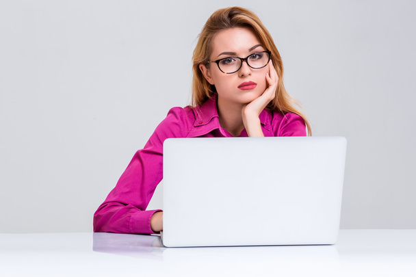 Tablo içinde oturan ve dizüstü bilgisayar kullanarak genç kadın - Fotoğraf, Görsel