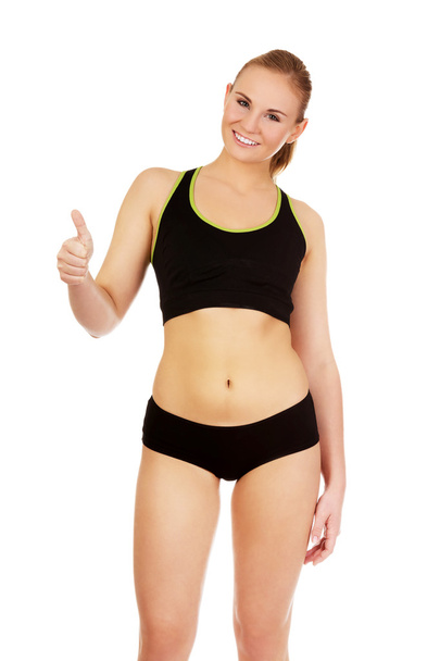 Young athletic woman showing thumb up - Foto, immagini