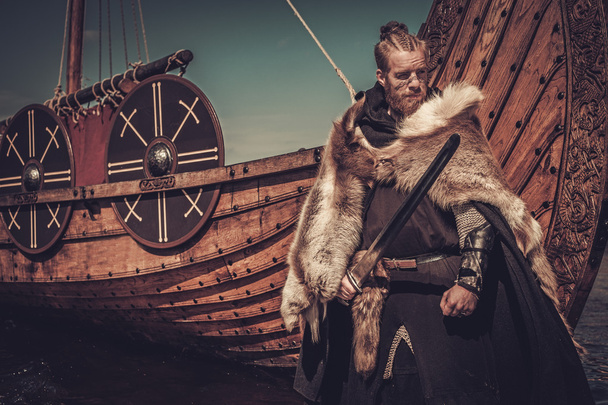 Viking bojovník s mečem stojící poblíž Drakkar  - Fotografie, Obrázek