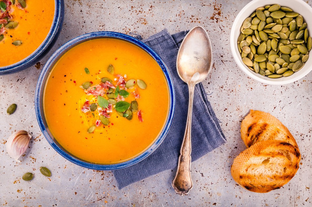 homemade autumn butternut squash soup with pumpkin seeds, bacon and basil - Photo, Image