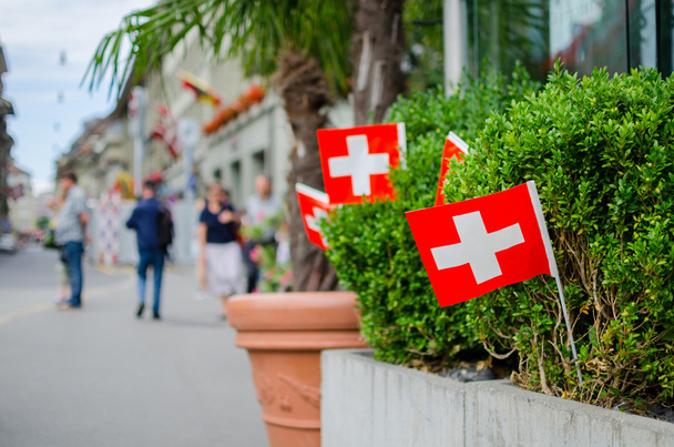 swiss flags hang outdoor on Swiss National Day in Bern - Photo, Image