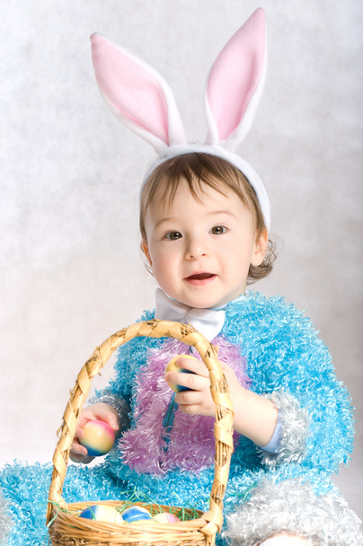 A small child dressed as a rabbit, basket and Easter eggs. - Fotó, kép