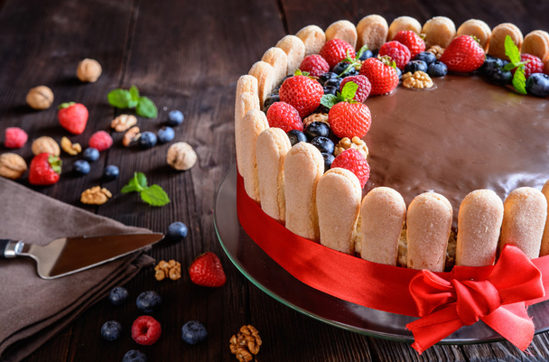 Saksanpähkinät kakku mansikoita, mustikoita ja savoiardi keksi
 - Valokuva, kuva