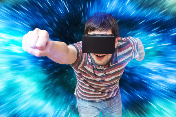 Jovem feliz está jogando videogame de corrida em 3D simulador de realidade virtual usando fone de ouvido. Voando em realidade virtual
. - Foto, Imagem