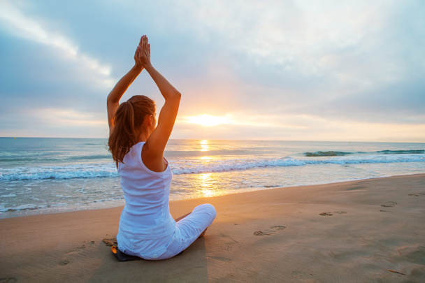 Caucasian woman practicing yoga at seashore - Foto, Imagen