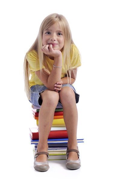 Girl seated on a stack of books - Foto, immagini
