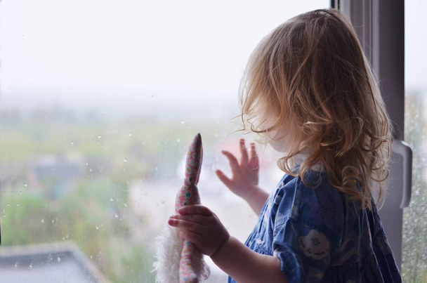 Gyermek lány nézett esőcseppek az ablakon - Fotó, kép