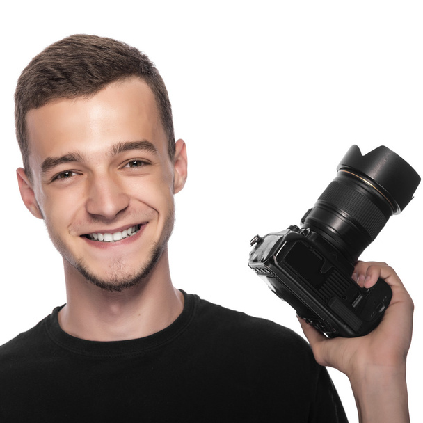 Handsome young man holding a DSLR camera. - Zdjęcie, obraz