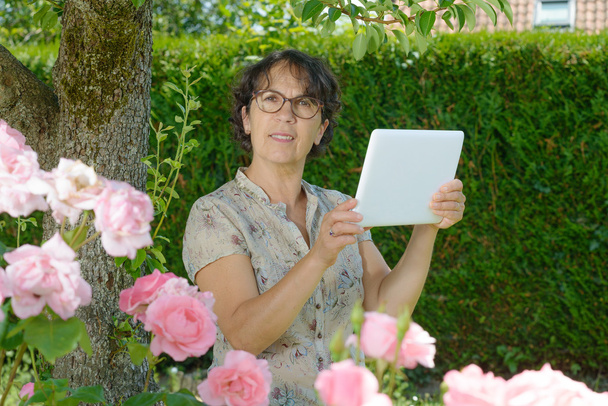egy tabletta, a kert érett nő - Fotó, kép