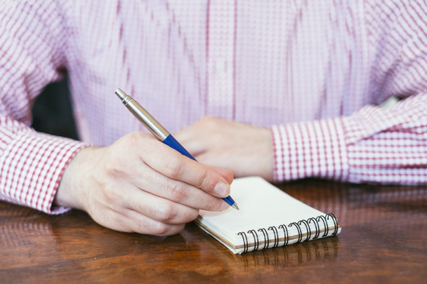 Hombre de oficina escribiendo notas sobre notas en bloque
 - Foto, Imagen