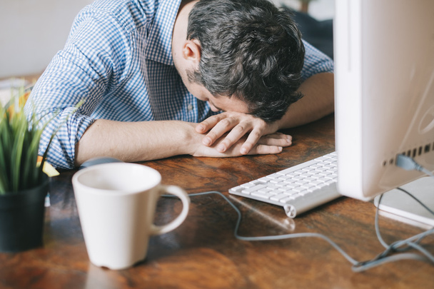 Müder Büroangestellter schläft vor seinem Arbeitsplatz - Foto, Bild